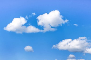 Mavi gökyüzünün arka planında kabarık beyaz bulutlar.