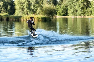 Yaz günü can yeleğiyle gölde uyanan bir adam. Yumuşak odaklanma. Eylem bulanıklığı. 