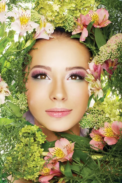 Woman in frame of flowers and herbs Stock Picture