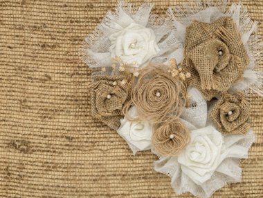 Flower rose made of fabric on burlap background with space for text clipart