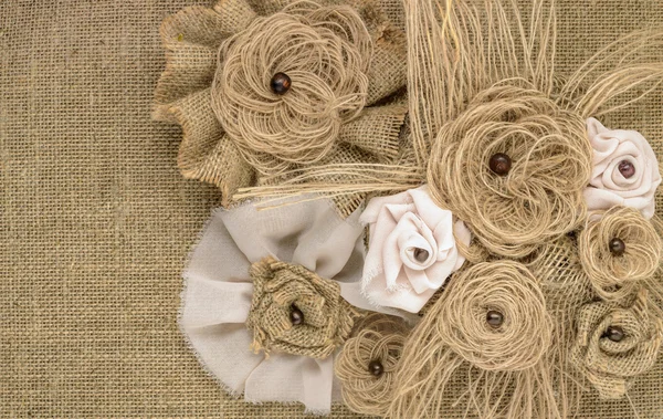 Fabric flowers close up on a background of burlap — Stock Photo, Image