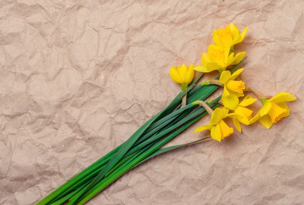 Buquê de narcisos amarelos sobre papel amassado com espaço para texto — Fotografia de Stock