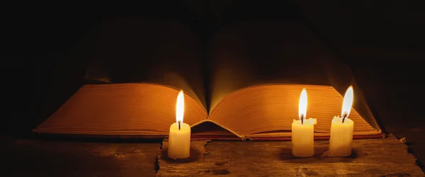 Large open book and candles — Stock Photo, Image