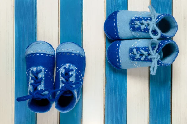 Children's shoes and blue colored wooden strips — Stock Photo, Image