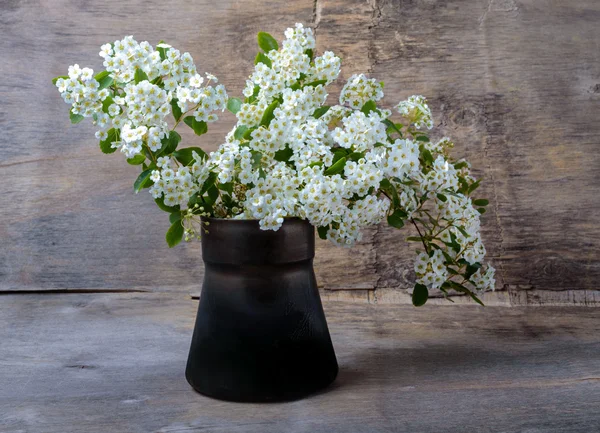 Bouquet of white flowers in a metal vase on  wooden background — Stock Photo, Image