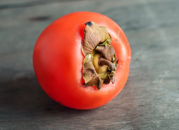 Ripe orange persimmon on the wooden background — Stock Photo, Image