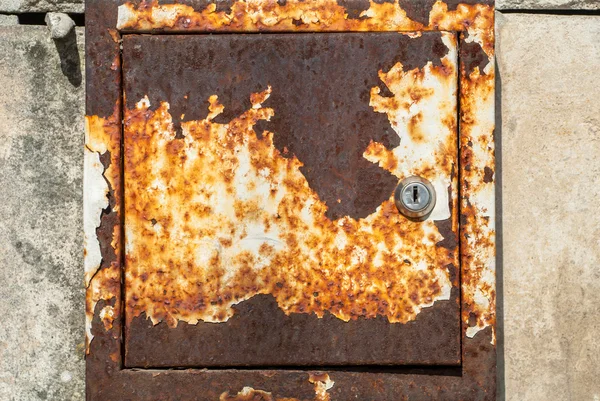 Beton duvar doku arka plan üzerinde eski paslı metal kutu