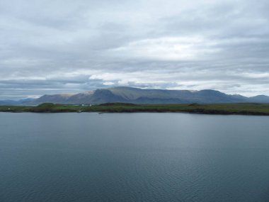 Overwhelming nature on the edge of the Icelandic capital Reykjavik, on the left the residence of the President of the Republic 