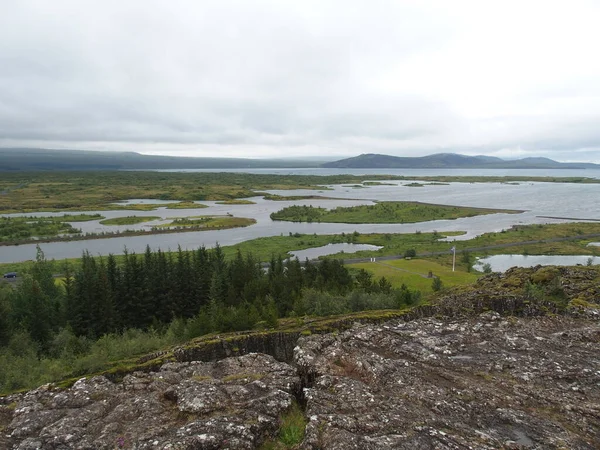 Pingvalla Gölü 'nün arka planında, İzlanda' nın Pingvellir bölgesinde Avrupa ile Kuzey Amerika arasındaki Rift Vadisi yer almaktadır.