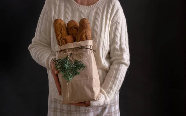 休日やクリスマスのためのパンと女性の手を保持ショッピングバッグ デリバリーコンセプト — ストック写真