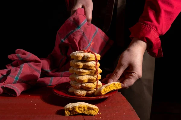 Mani Mostrano Biscotti Sul Tavolo Legno Rosso Sullo Sfondo Nero — Foto Stock