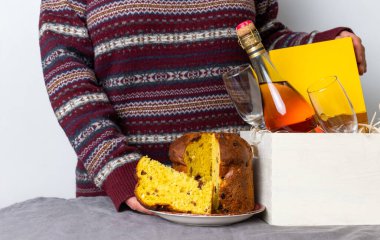 Paskalya panetonu taşıyan kadın. İtalyan malı. Yanında da şampanya şişesi var..