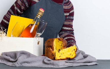 Paskalya panetonu taşıyan kadın. İtalyan malı. Yanında da şampanya şişesi var..