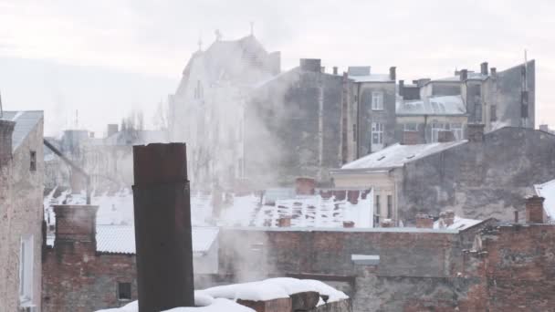 煙突から煙の蒸気が街の背景に屋根の上に — ストック動画