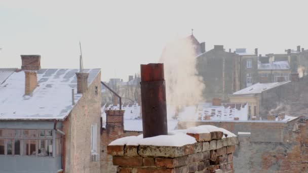 煙突から煙の蒸気が街の背景に屋根の上に — ストック動画