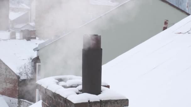 煙突から煙の蒸気が街の背景に屋根の上に — ストック動画