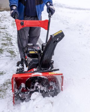 İşçi, kışın kar fırtınası ile sokakları ya da bahçeleri temizler.