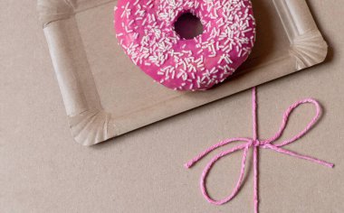 Kağıt teslimat kutusunda kırmızı fiyonklu Pembe Kek..