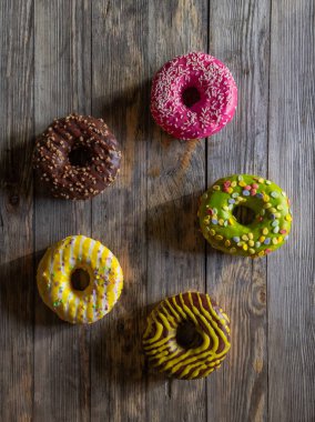 Ahşap zemin üzerinde farklı yuvarlak pastalar kümesi, üst görünüm