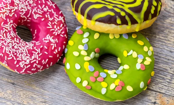 Ahşap arka planda üç farklı yuvarlak pasta, üst manzara.