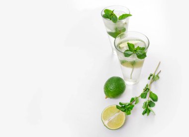 Kokteyl Cin Toniği ya da bardakta mojito. Beyaz arka planda nane, buz, limon..