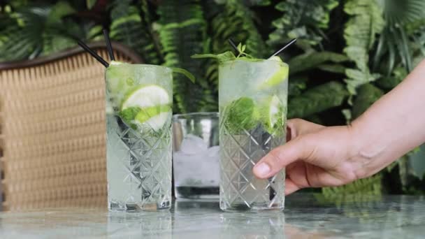 Tangan Menempatkan Dua Cocktails Gin Tonic Atau Mojito Dengan Gin — Stok Video