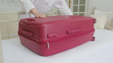 Bir Kadın Yatağa Kapanıyor Pembe bir bavul Elbiseli.
