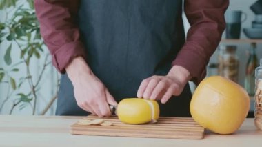 Adamın elleri Hollanda peynirini, Edam peynirini ve keçi peynirini kesti.