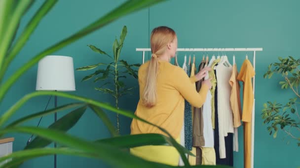 Middle Aged Blond Woman Maakt Winkelen Kijkt Naar Nieuwe Jurken — Stockvideo