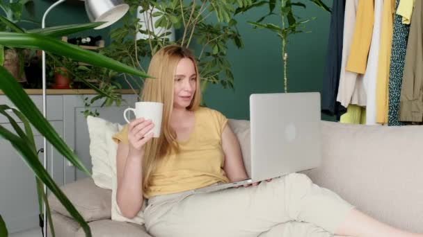 Middle Aged Blond Woman Sitting Sofa Communicates Online Laptop — Stock Video