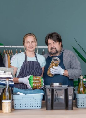 Erkekler ve kadınlar yardım ve bağışta bulunmak için giysi ve ürünleri kutulara koyuyorlar..