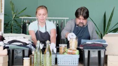 Erkekler ve kadınlar yardım ve bağışta bulunmak için giysi ve ürünleri kutulara koyuyorlar..
