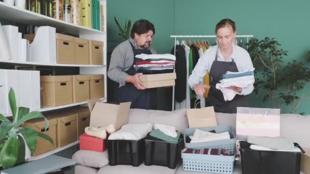 Άνδρες Και Γυναίκες Συσκευάζουν Κουτιά Ρούχα Και Προϊόντα Για Φιλανθρωπία — Αρχείο Βίντεο