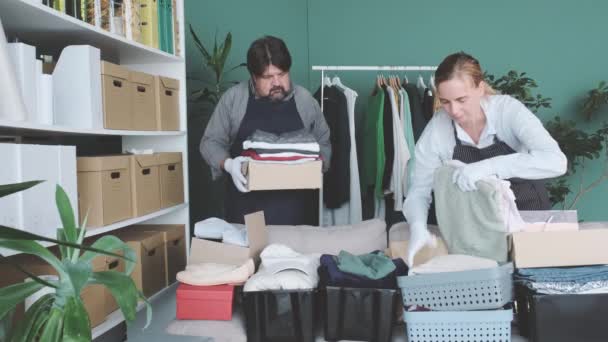 Männer Und Frauen Packen Kartons Kleidung Und Produkte Für Wohltätige — Stockvideo