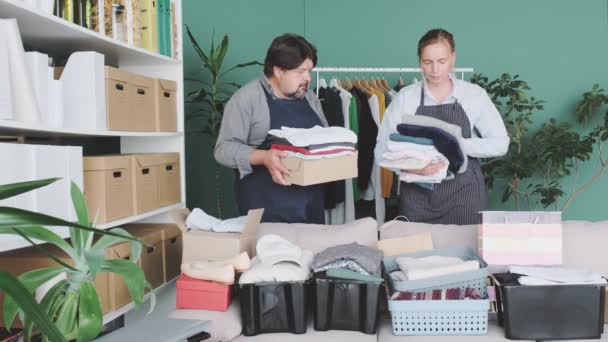Άνδρες Και Γυναίκες Συσκευάζουν Κουτιά Ρούχα Και Προϊόντα Για Φιλανθρωπία — Αρχείο Βίντεο