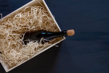 Mavi ahşap arka planda şarap şişesi olan saman depoya, teslimat servisi.