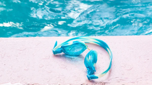 Blue glasses on pool and water background