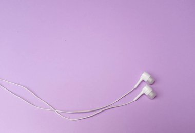 Üst ve düz yatar Beyaz kulaklıklar veya Kulaklıklar mor renkli arka planda izole edilir