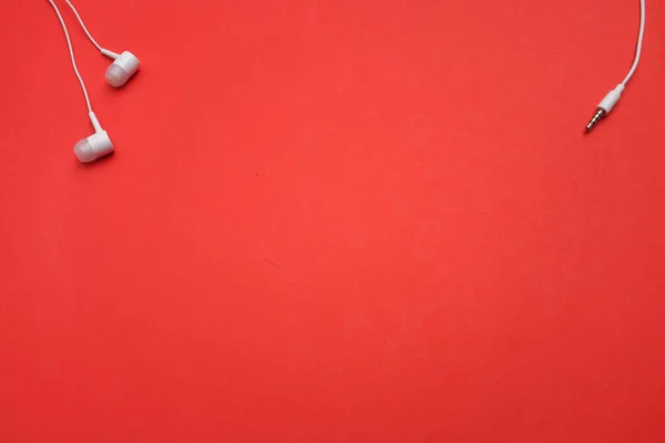 close up White headphones or Earphons isolate on a red background