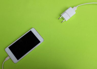 Üst görünüm Smartphone yeşil arkaplanda Charger ile bağlanır.