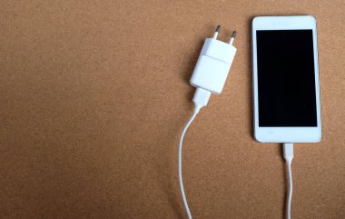 Uzayı kopyala Akıllı Telefon Kahverengi Arkaplanda Şarj Arkaplanı ile Bağlanır.