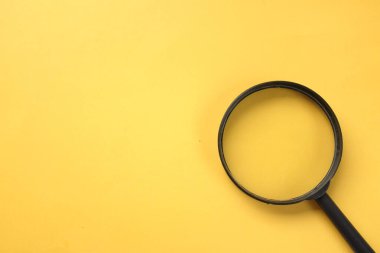 Büyüteç, sarı bir arkaplanda izole edilmiş. Arama sembolü ve genişleyen berraklık.