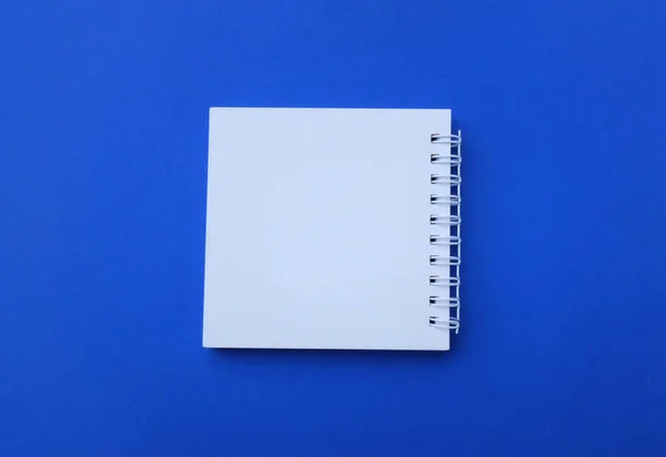 フラットレイとトップビュー空白の白いスパイラルノートパッドデスクブルーの背景 教育とビジネスコンセプト — ストック写真