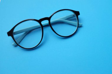 copy space round black Eye Glasses isolate on blue Background clipart