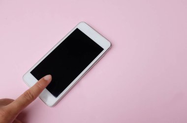 Pembe pastel arka planda akıllı telefona dokunmanın kopyalama alanı