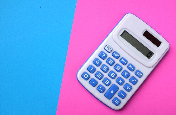 A blue calculator on the two tone color blue and pink background