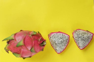 Üst manzara leziz ve tatlı, parlak sarı arka planda izole edilmiş Ejder meyvelerinin yarısında. 