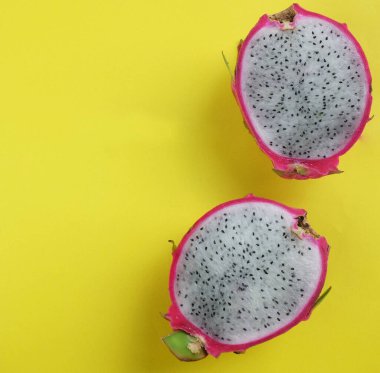 Parlak sarı bir zemin üzerinde izole edilmiş Ejderha meyvelerinin yarısında leziz ve tatlı bir kopyalama alanı 