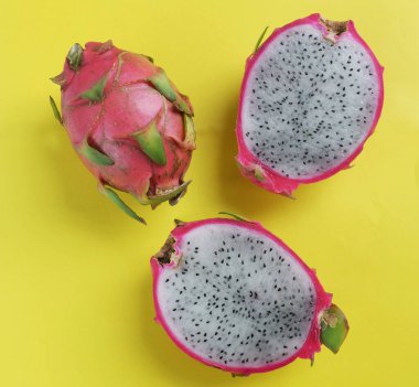 Üst manzara leziz ve tatlı, parlak sarı arka planda izole edilmiş Ejder meyvelerinin yarısında. 