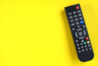 Sarı parlak arkaplanda televizyon izlemek için alanı ve üst görünüm TV uzaktan kumandasını kopyala